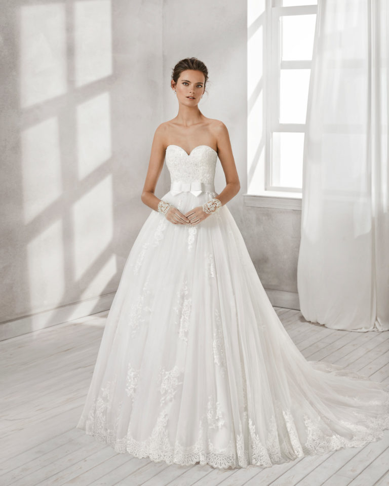 A-line beaded lace and tulle wedding dress with sweetheart neckline and bow at waist.