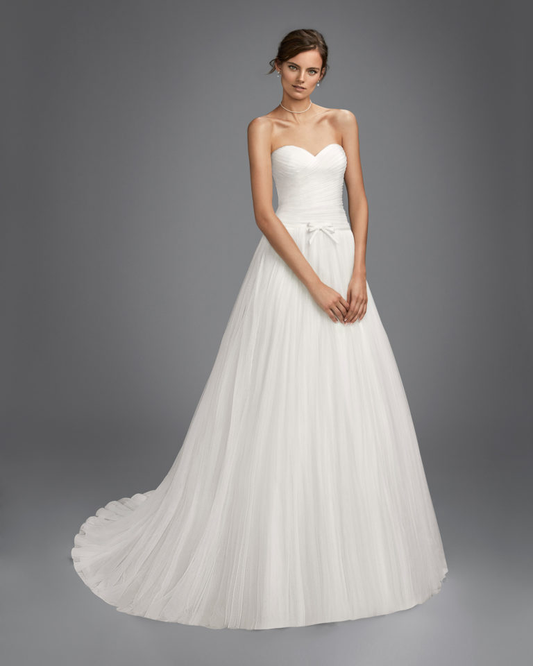 Romantic-style tulle wedding dress with sweetheart neckline and bow at waist.