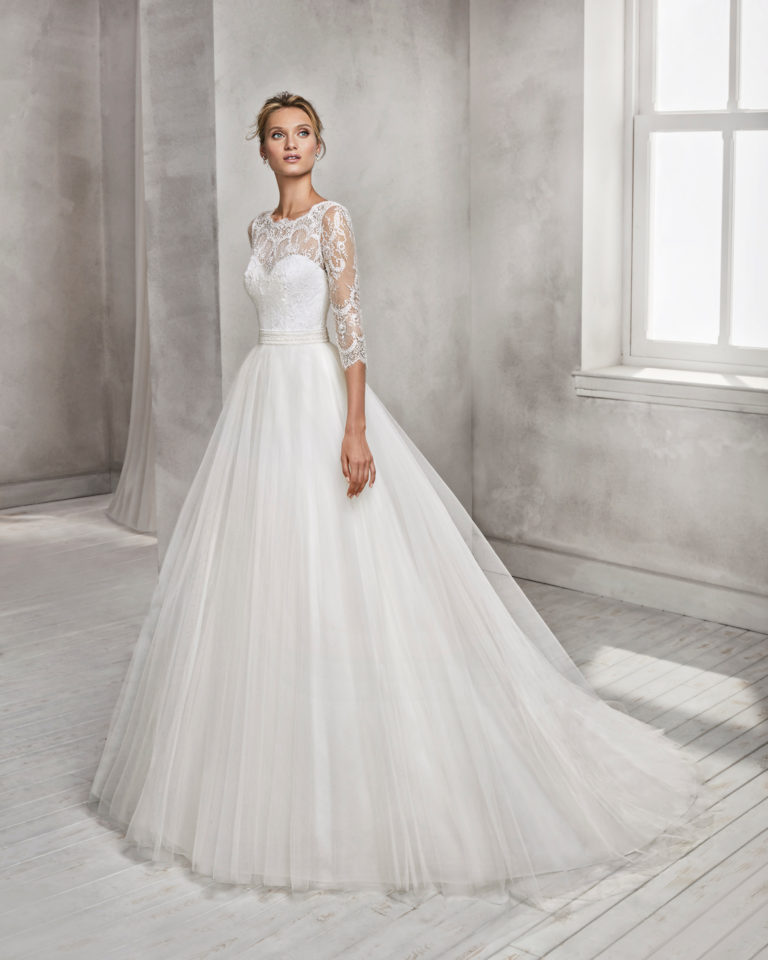 Princess style beaded lace and tulle wedding dress with three-quarter sleeves and illusion neckline.