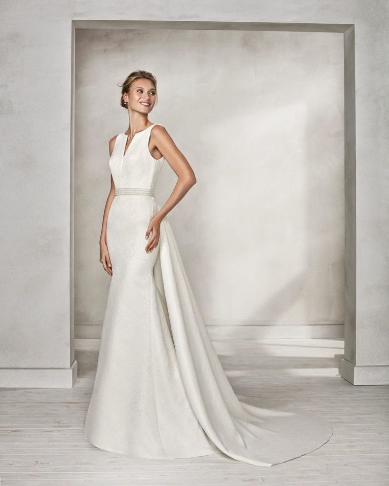Mermaid-style beaded brocade wedding dress with bateau neckline and train.