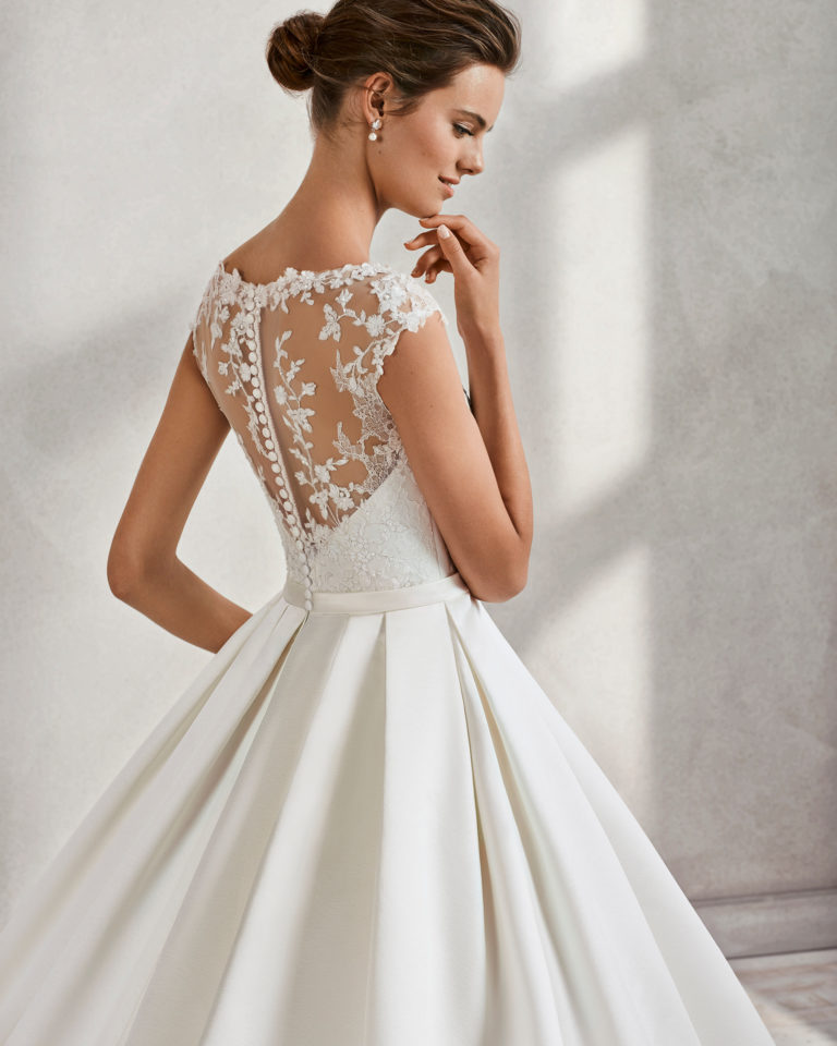 Classic-style beaded lace and duchess satin wedding dress with illusion neckline, in ivory.
