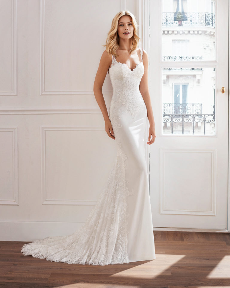 Vestido de novia corte recto en crepe. Con cuerpo de encaje con pedrería y encaje incrustado en la falda. Disponible en color natural. Colección  2019.