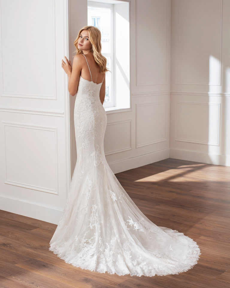 Vestido de novia corte sirena de encaje. Escote corazón, tirante de pedrería y falda de aplicaciones. Disponible en color natural. Colección  2019.