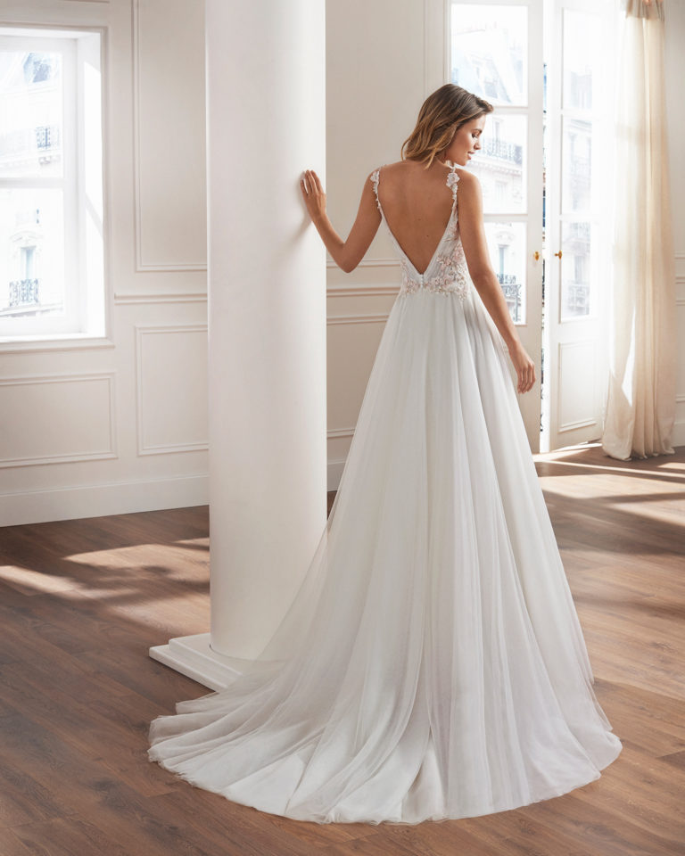 Vestido de novia estilo princesa en tul. Escote en V, cuerpo drapeado y detalles de encaje aplicados. Disponible en color natural/rosa y en natural. Colección  2019.