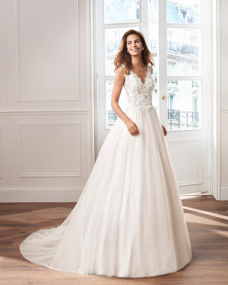 Tulle princess-style wedding dress. V-neckline and lace bodice with open back. Available in pink and natural. 2019  Collection.