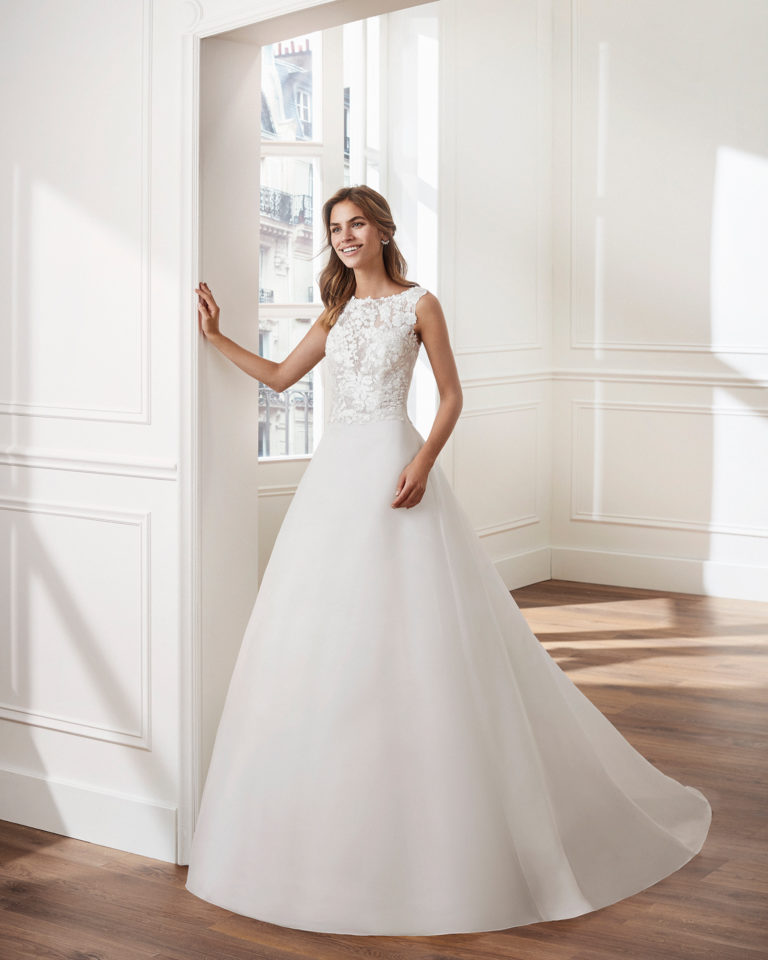 Vestido de novia estilo clásico línea A en gazar. Escote barco y cuerpo de encaje. Disponible en color natural. Colección  2019.