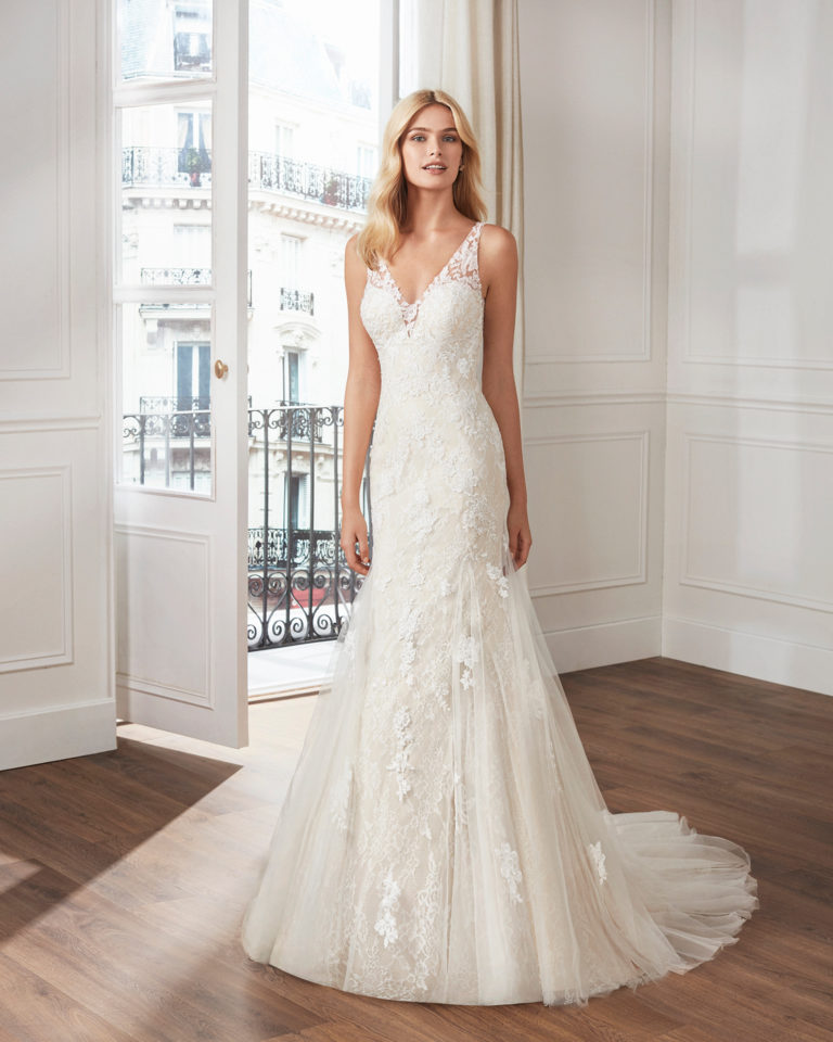 Mermaid-style wedding dress in beaded lace. V-neckline and teardrop back with appliquéd skirt. Available in natural and natural/champagne. 2019  Collection.