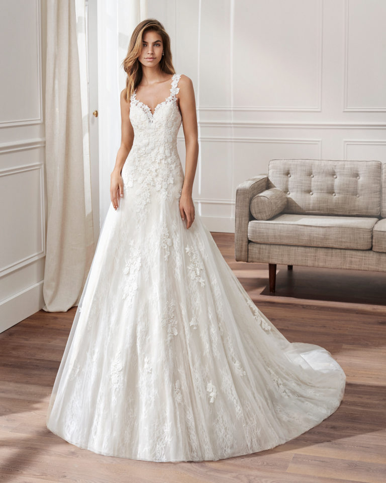 Ballgown-style wedding dress in lace. Sweetheart neckline, straps and appliquéd skirt. Available in natural and natural/nude. 2019  Collection.