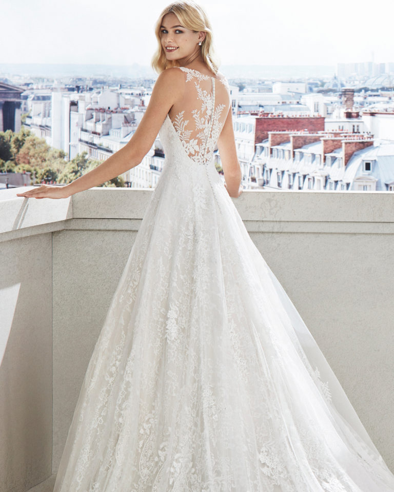 Vestido de novia corte evasé en encaje. Escote corazón, tirantes de pedrería y aplicaciones en falda. Disponible en color natural y natural/rose. Colección  2019.