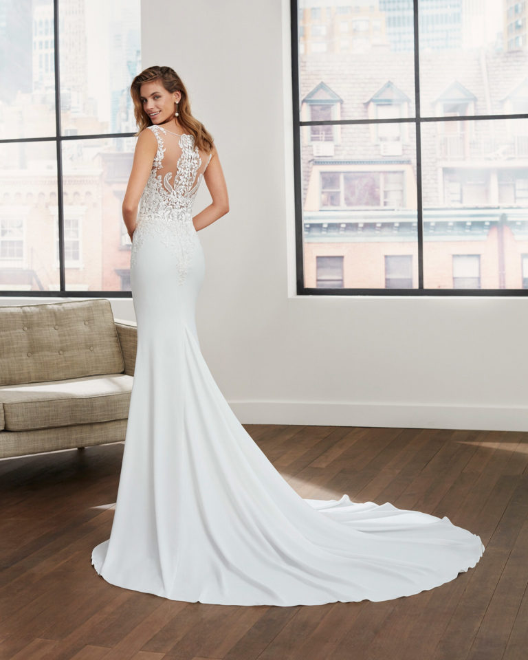 Vestido de novia corte sirena de crep elástico, encaje y escote y sisa de pedrería con escote deep-plunge y espalda efecto tattoo. Colección 2020.