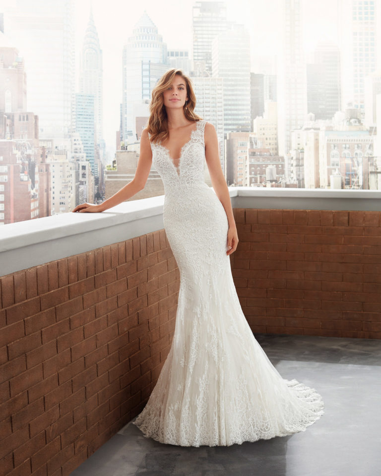 Mermaid-style lace and tulle wedding dress, dee p-plunge neckline and low back. 2020 Collection.