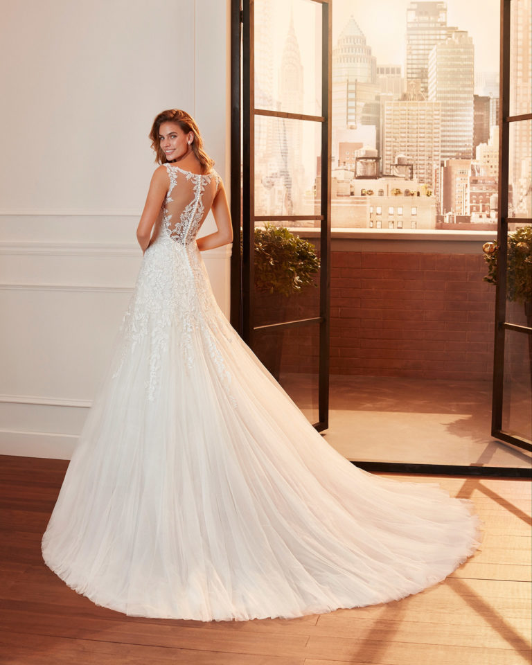 Vestido de novia de estilo romántico de encaje y tul con escote en V y espalda con transparencias. Colección 2020.