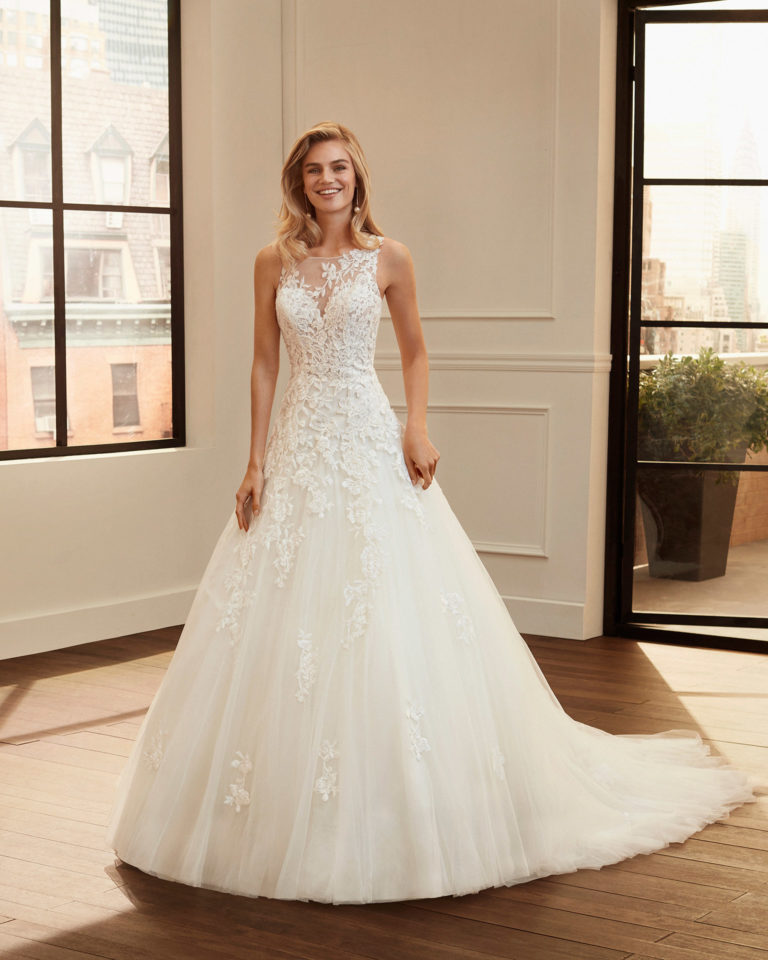 Vestido de novia de estilo romántico de encaje rebrodé y tul con escote y espalda de transparencias. Colección 2020.