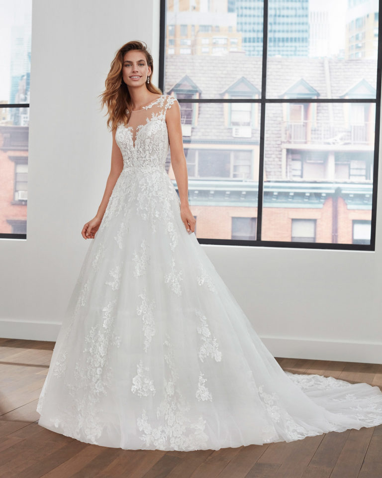 Vestido de novia de estilo princesa de encaje, tul y pedrería con escote y espalda de transparencias. Colección 2020.