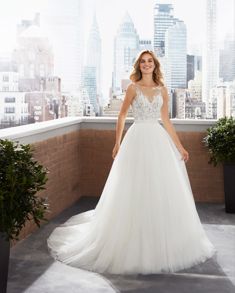 Vestido y sobrefalda de novia estilo princesa de tul, crep, encaje con escote y cintura pedrería. Colección 2020.