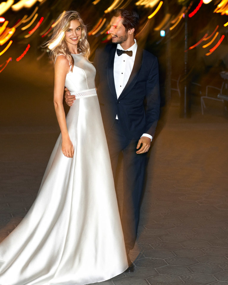 Vestido de novia estilo línea A de mikado y encaje, escote barco y espalda escotada con pasamanería. Colección 2020.