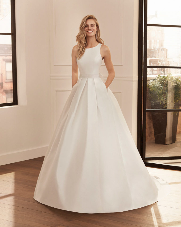 Vestido de novia estilo clásico de bari y cinturón de encaje con escote barco y espalda cruzada. Colección 2020.