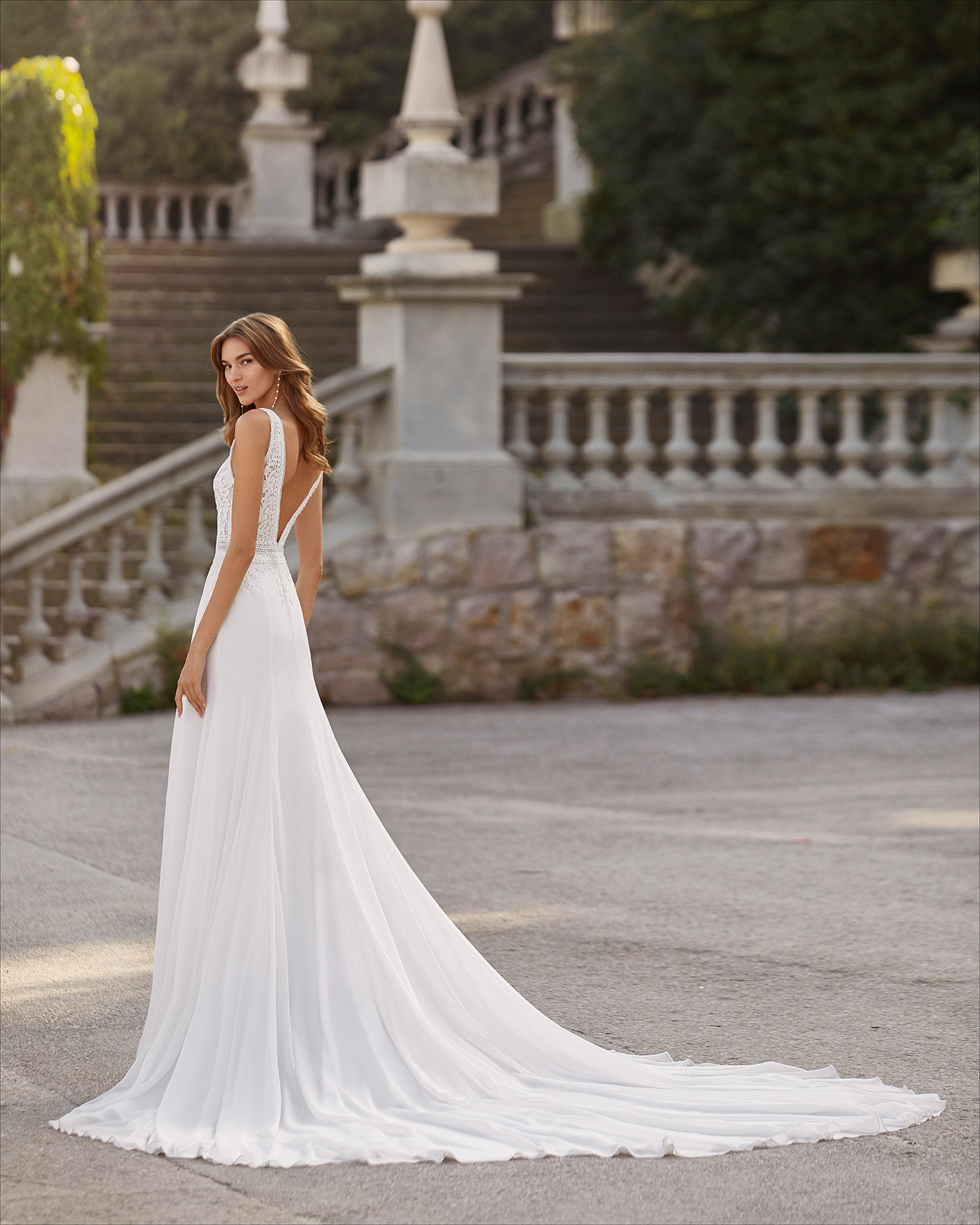 Ballgown-style wedding dress in chiffon and lace. Deep-plunge neckline and V-back. 2021  Collection.