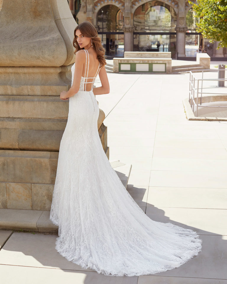Sheath-style wedding dress in beaded lace. V-neckline and open back with shoulder straps. 2021 Collection.