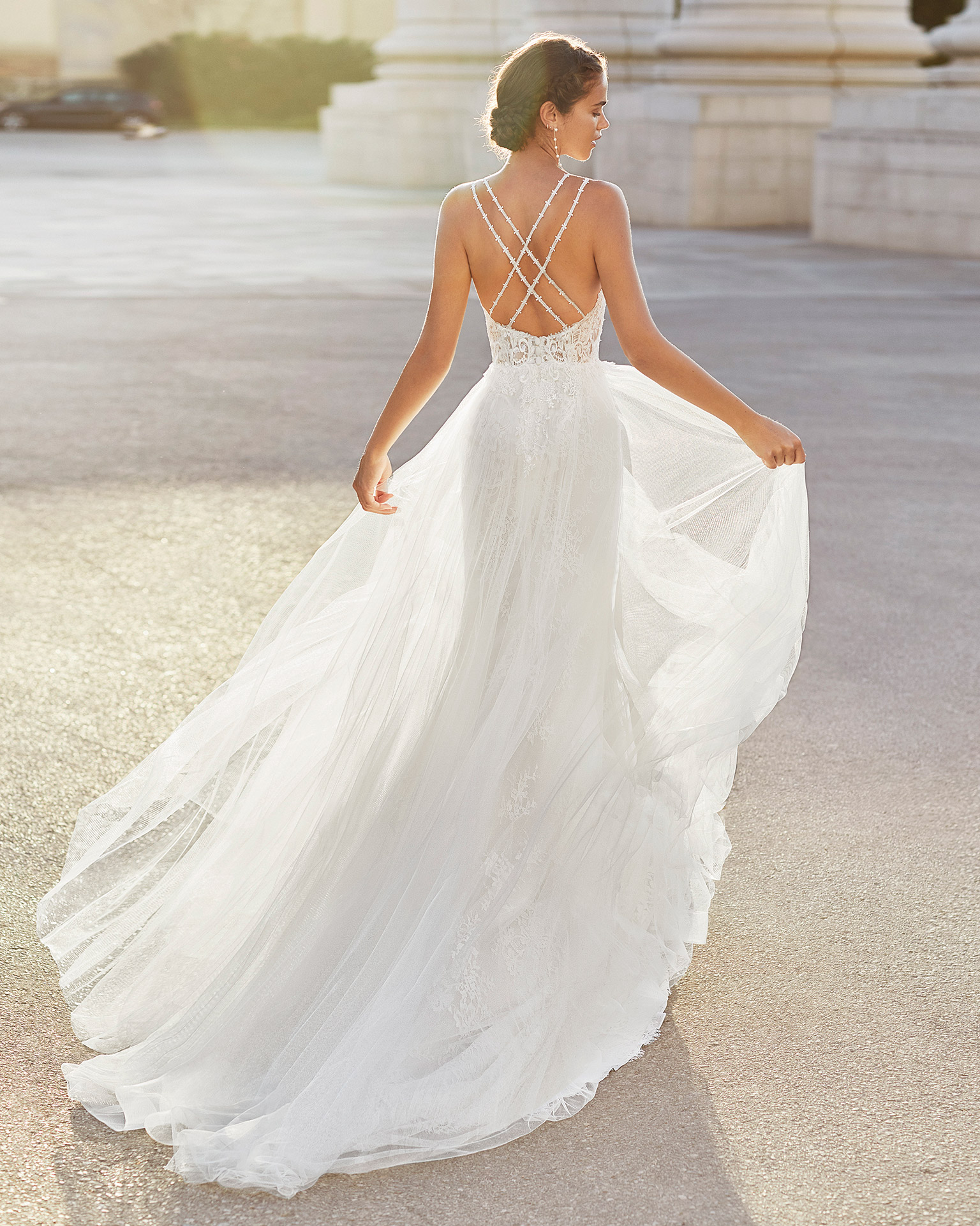 Sheath-style wedding dress in tulle and beaded lace. Deep-plunge neckline and open back with crossover shoulder straps. 2021  Collection.