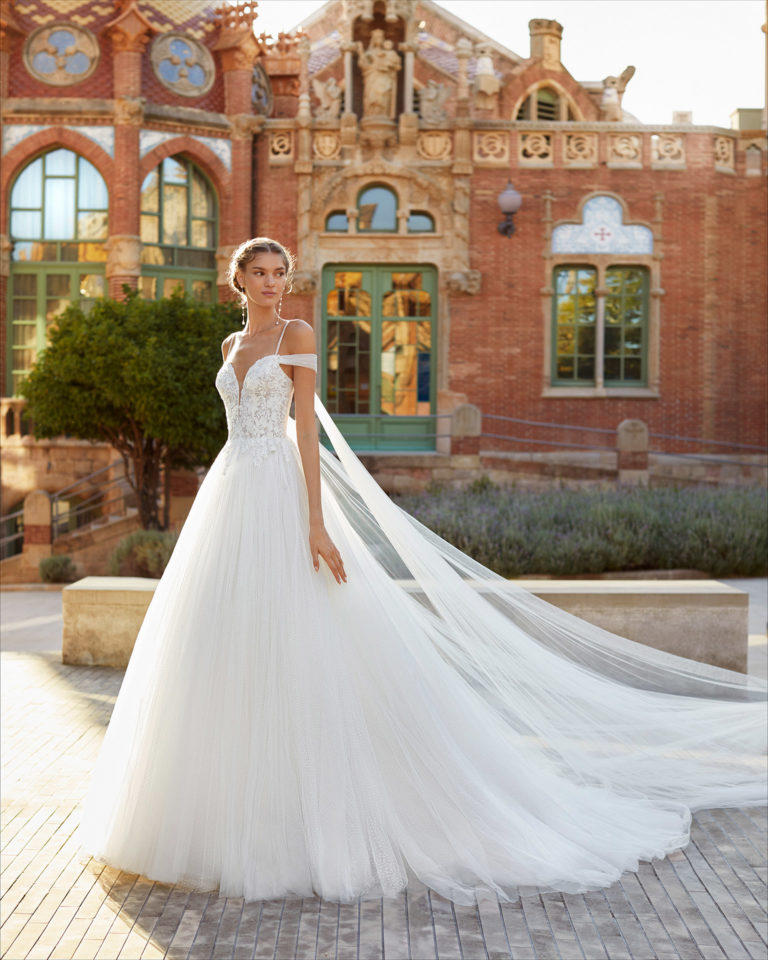 Romantic-style wedding dress and flaps in dot tulle and beaded lace. Bardot neckline, spaghetti shoulder straps and tulle flaps. 2021 Collection.