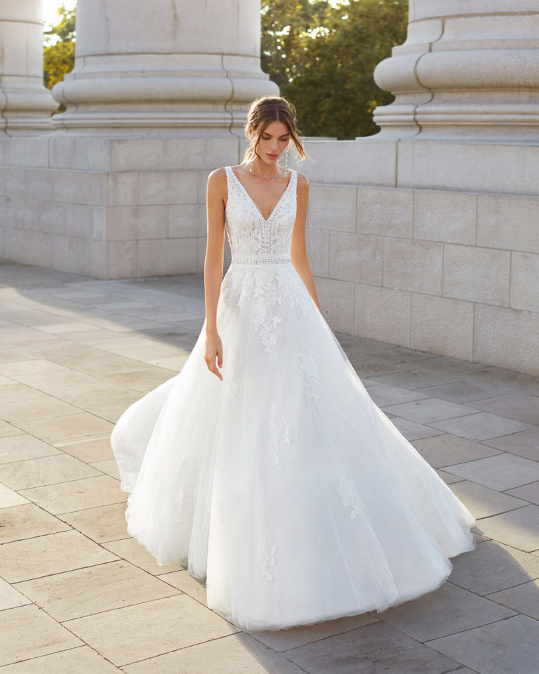 Ballgown-style wedding dress in dot tulle and beaded lace. V-neckline and slit back. 2021  Collection.