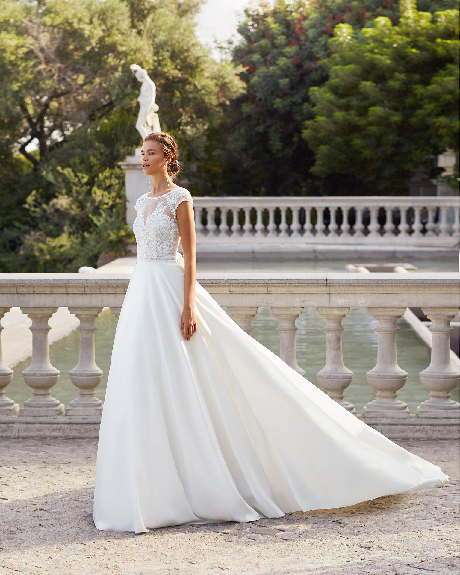 Classic-style wedding dress in satin and beaded lace. Yoke in dot tulle, with bow at back and pockets. 2021  Collection.