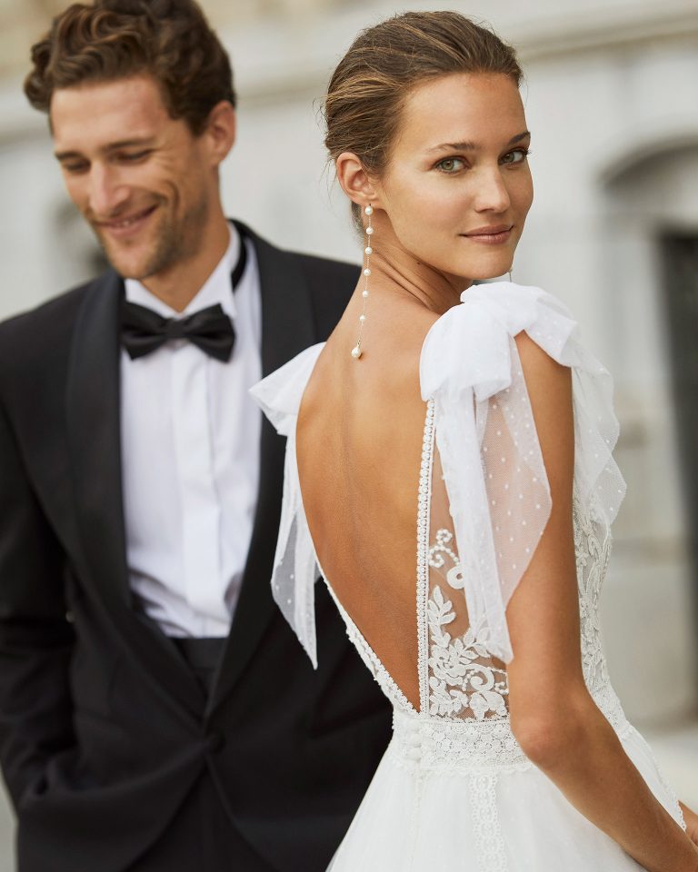 Romantic wedding dress, dot tulle, lace and beaded neckline and waist. Deep-plunge neckline, V-back and dot tulle bows on the shoulders. 2022 Collection.
