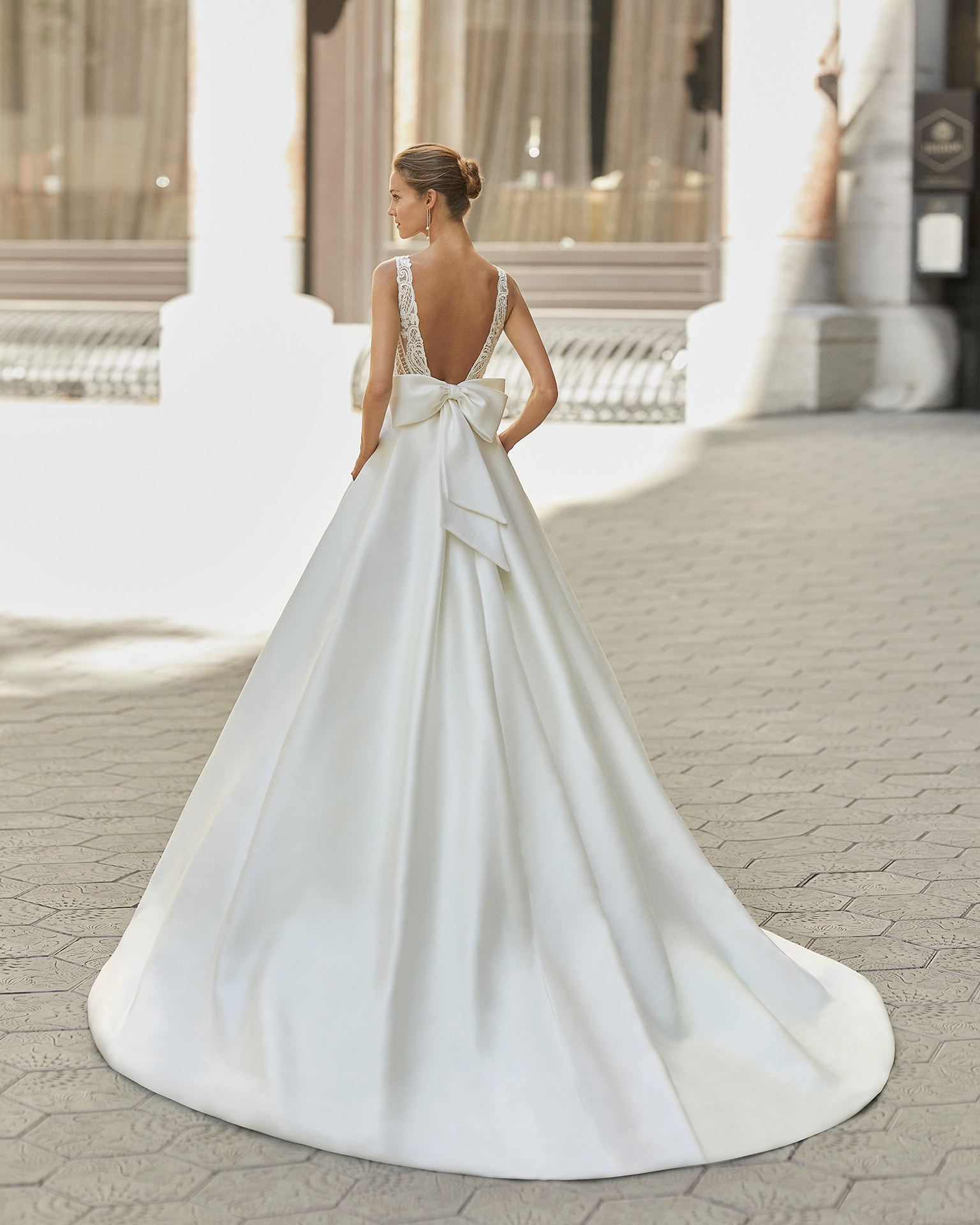 Vestido de novia de estilo clásico, raso, encaje y pedrería. Escote deep plunge y espalda escotada. Colección  2022.
