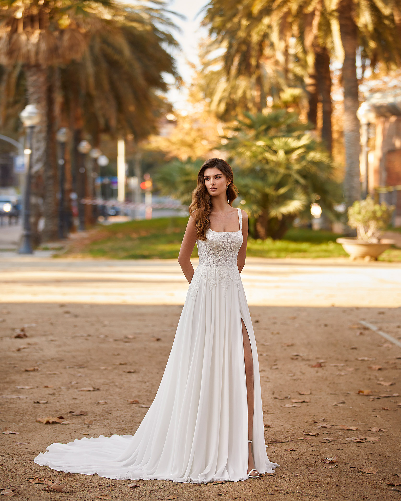 Flowing ballgown-style wedding dress made of Georgette, with a sheath-style skirt with a front slit; with a square neckline and a plunging lace back. Delicate Luna Novias design made of Georgette combined with beadwork lace. LUNA_NOVIAS.