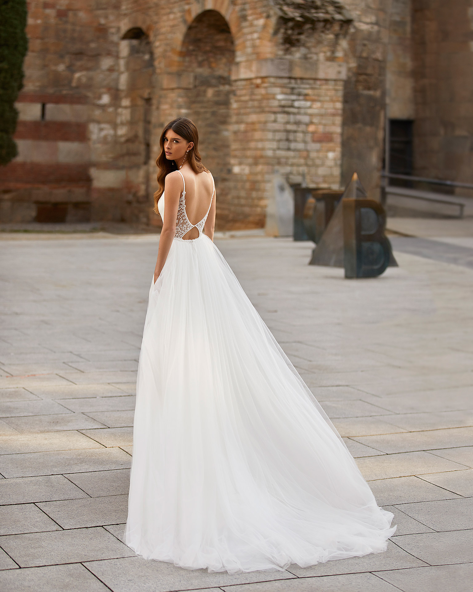 Two-piece sheath-style wedding dress made of stretch crepe, including a tulle overskirt; with a deep-plunge neckline and a lace and beadwork back. Dreamy Luna Novias outfit made of stretch crepe combined with beadwork lace and tulle. LUNA_NOVIAS.