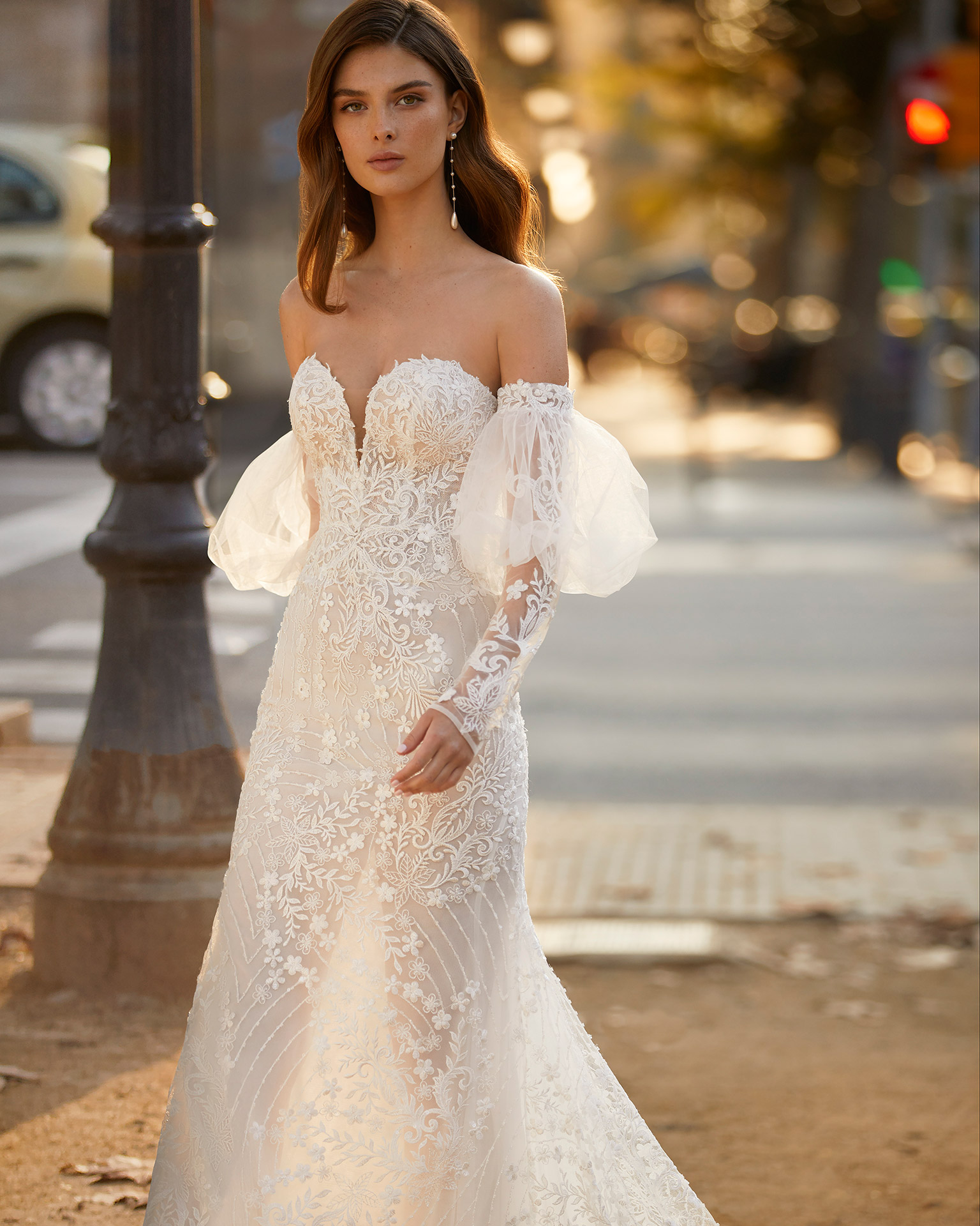 Romantic mermaid-style wedding dress, made of lace, with matching puffed sleeves; with a push-up corset structure, a button-up back, and long tulle and appliqué sleeves. Unique Luna Novias outfit made of lace with beadwork. LUNA_NOVIAS.