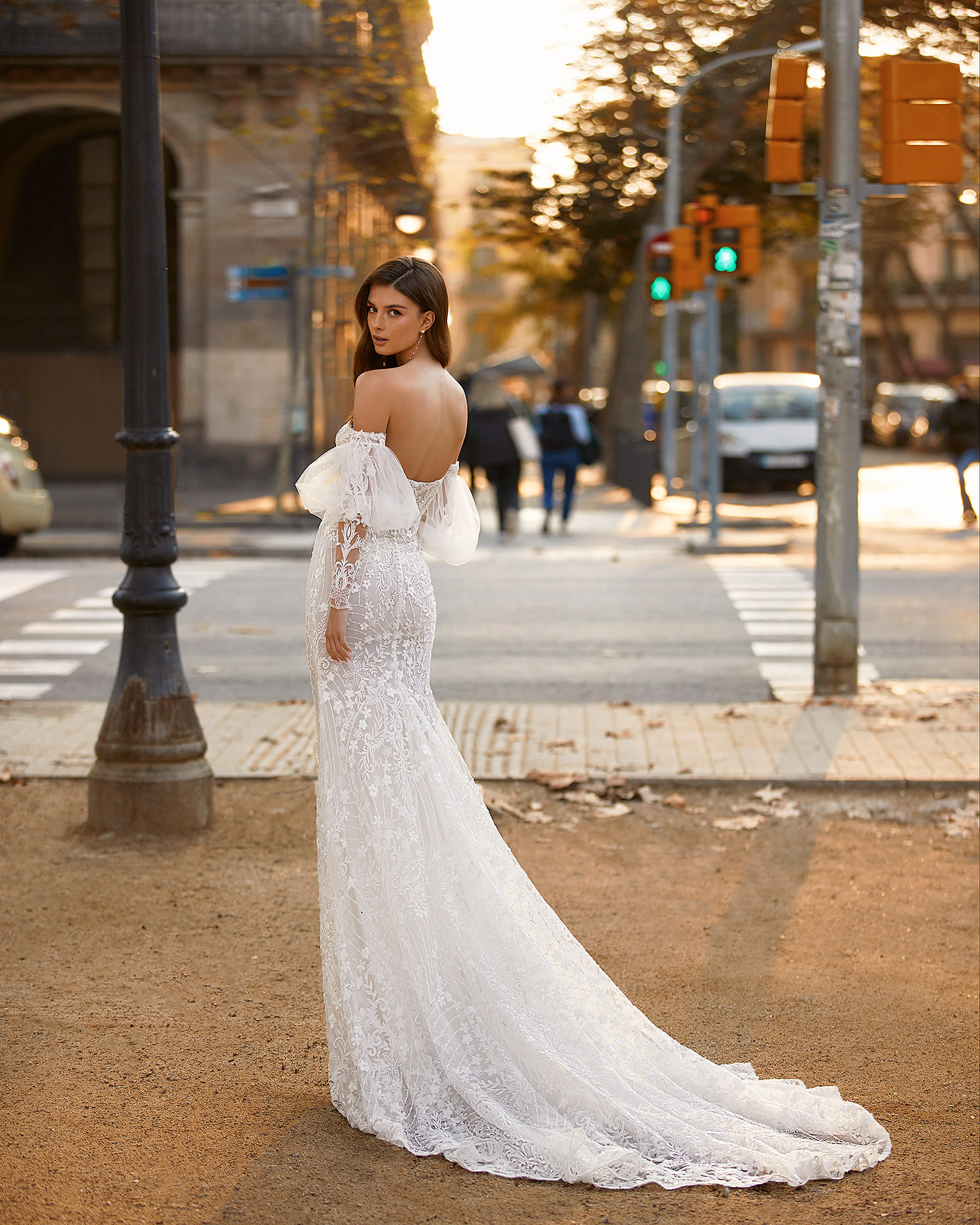 Romantic mermaid-style wedding dress, made of lace, with matching puffed sleeves; with a push-up corset structure, a button-up back, and long tulle and appliqué sleeves. Unique Luna Novias outfit made of lace with beadwork. LUNA_NOVIAS.