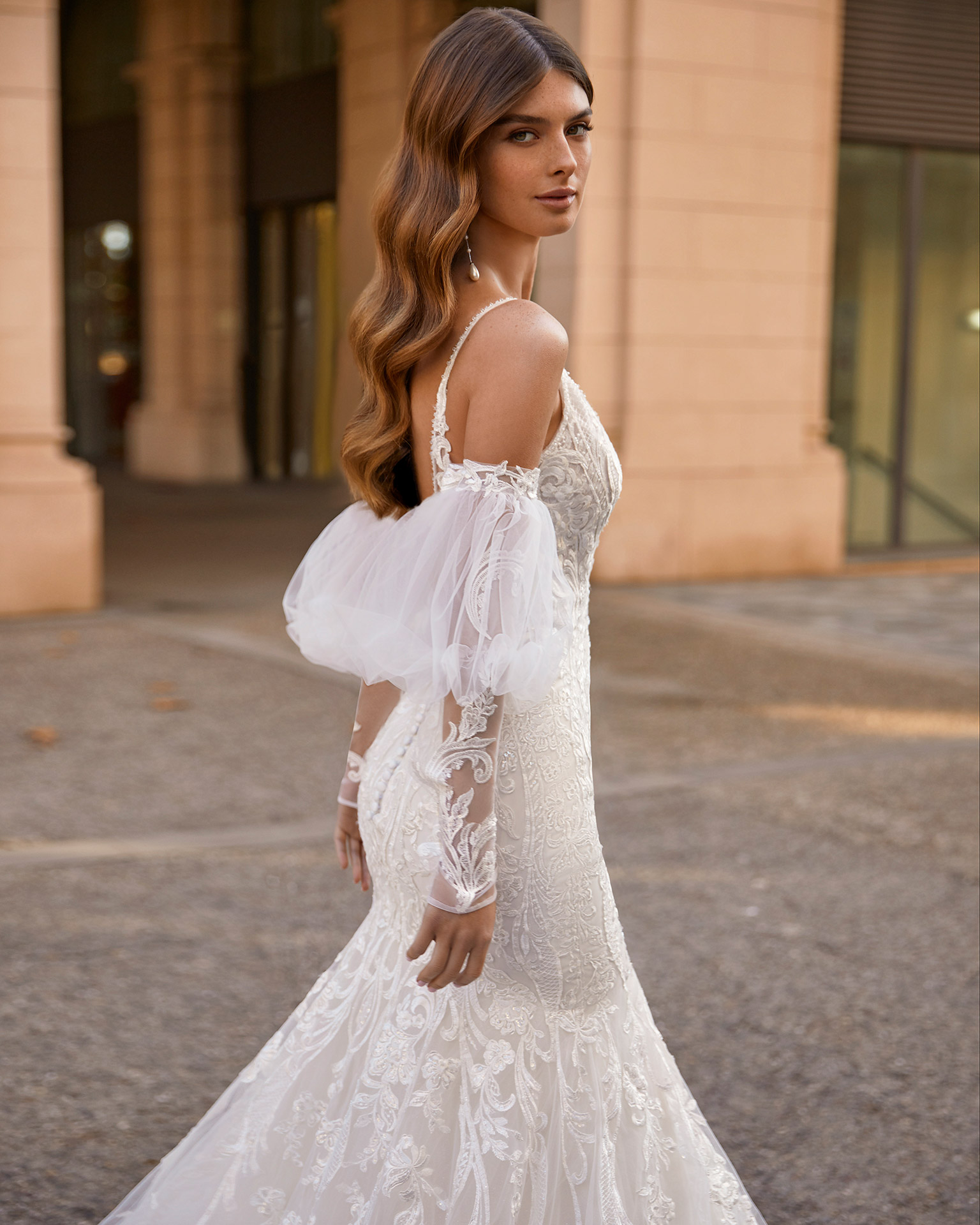 Romantic mermaid-style wedding dress, made of lace, tulle and shiny mesh, including puffed sleeves; with a V-neckline, an open back with sheer inserts, and long tulle and appliqué sleeves. Dreamy Luna Novias outfit made of lace with beadwork. LUNA_NOVIAS.