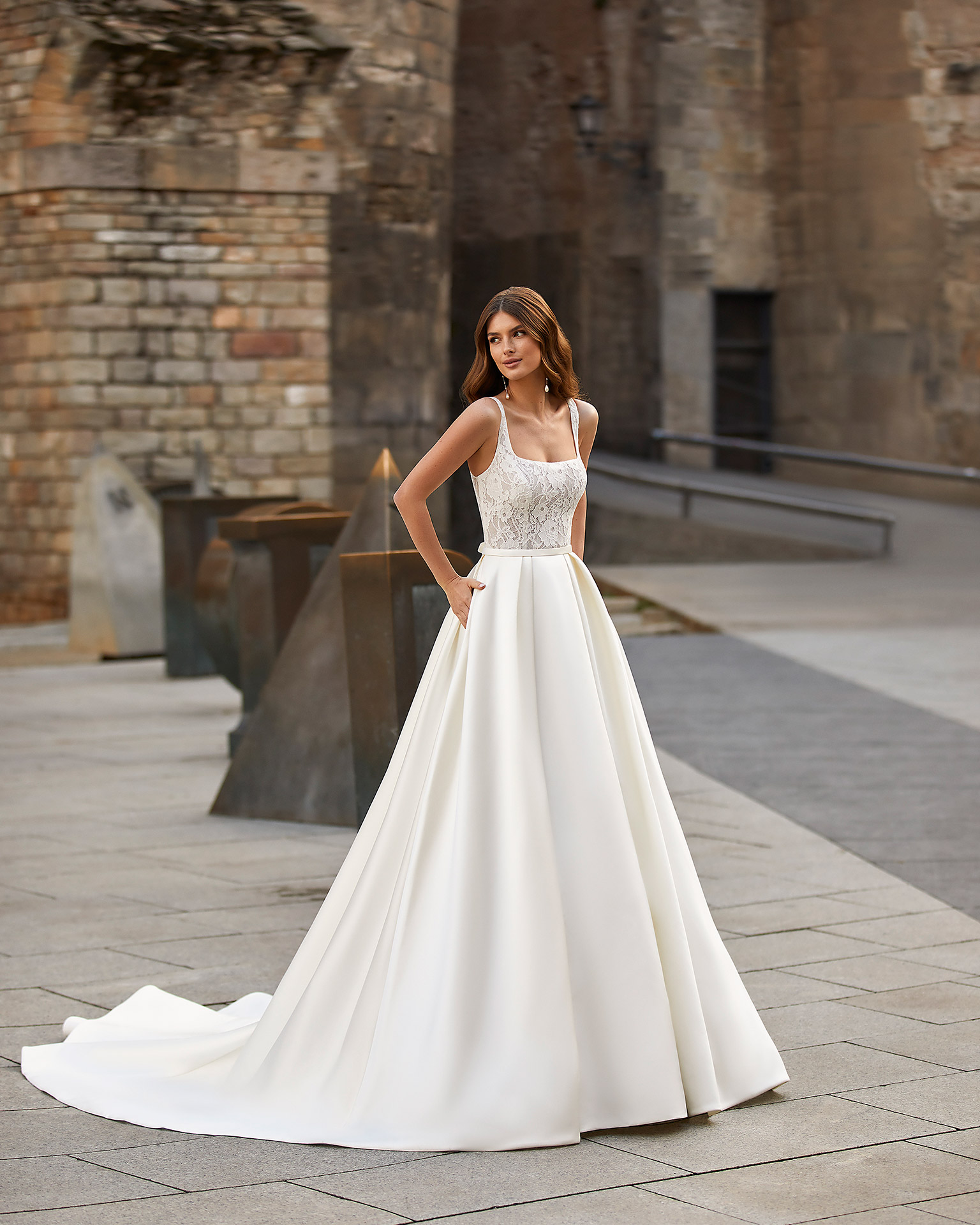 Classic-style wedding dress, made of satin, with a lace bodice; with a square neckline, an open back, and a bow at the back. Dreamy Luna Novias design made of satin combined with lace. LUNA_NOVIAS.