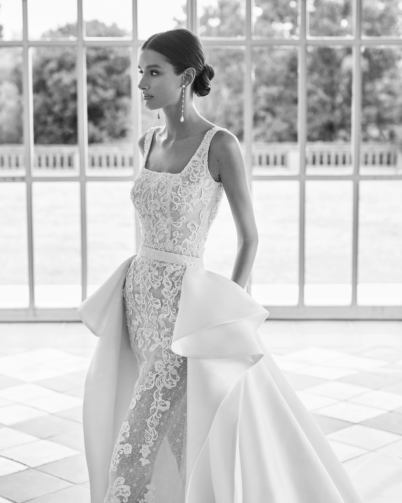 Two-piece mermaid-style wedding dress, with an overskirt with Mikado flounces; with a square neckline, an open back, and straps. Trendy Luna Studio outfit, made of tulle, lace, with beadwork, and Mikado. LUNA_NOVIAS.