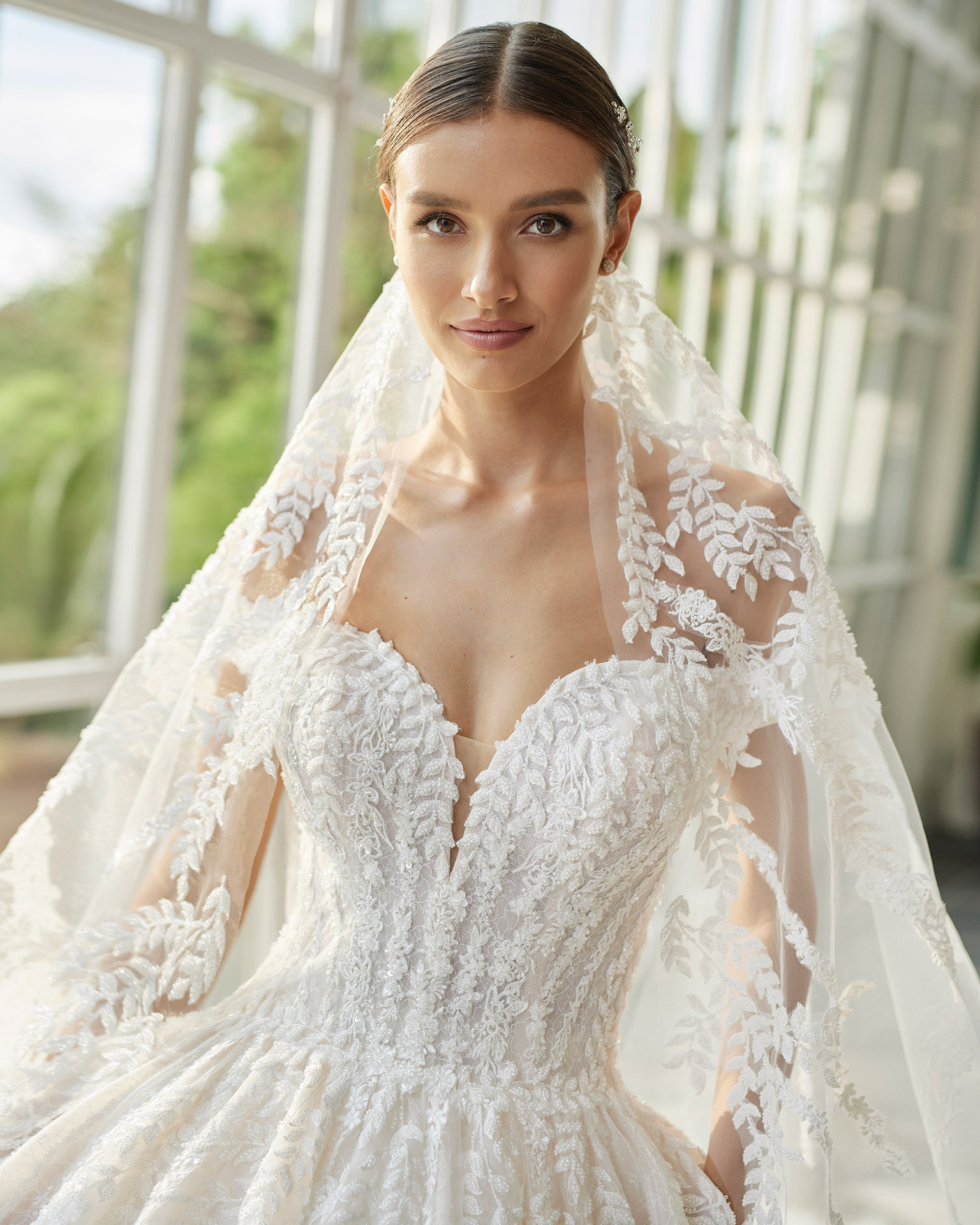 Princess-style wedding dress, with a beadwork embellished bodice; with a sweetheart neckline, a corset back, and dropped sleeves. Unique Luna Studio outfit made of tulle embellished with beadwork lace. LUNA_NOVIAS.