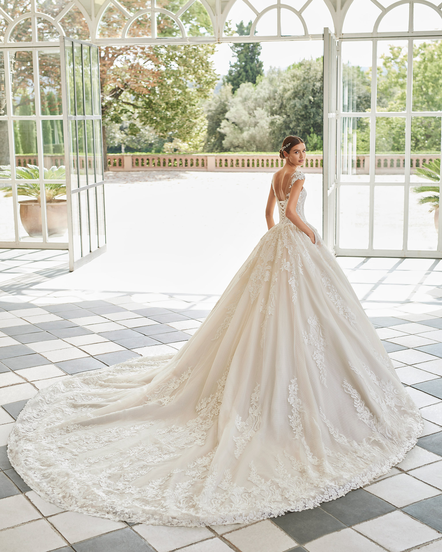 Romantic princess-style wedding dress, with a sheath-style skirt with pockets; with an illusion neckline, and a corset back. Luna Studio dress made of tulle and lace, with beadwork finishes. LUNA_NOVIAS.