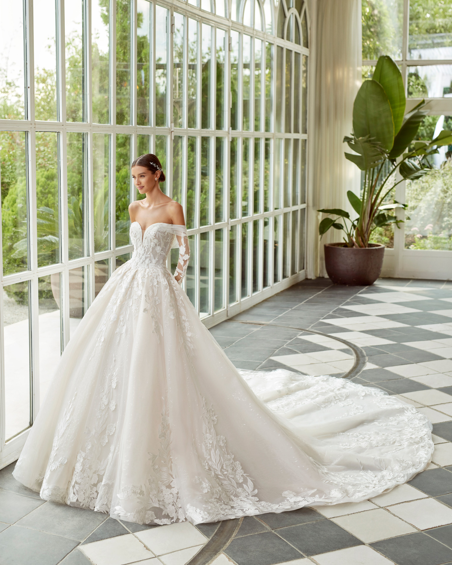 Princess-style wedding dress, with a full sheath-style skirt and shiny mesh; with a sweetheart neckline, a corset back, and long sleeves. Dreamy Luna Studio design made of tulle and lace, with beadwork finishes. LUNA_NOVIAS.