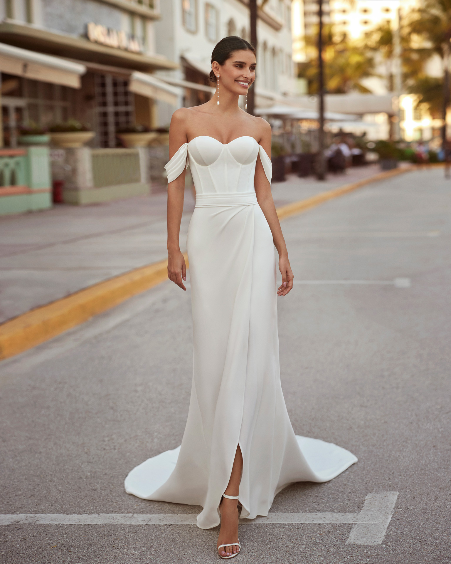 Elegant short  wedding dress, made in crepe. It features a sweetheart neckline, corset back, detachable straps and overskirt with a side slit. Luna Novias design. LUNA_NOVIAS.