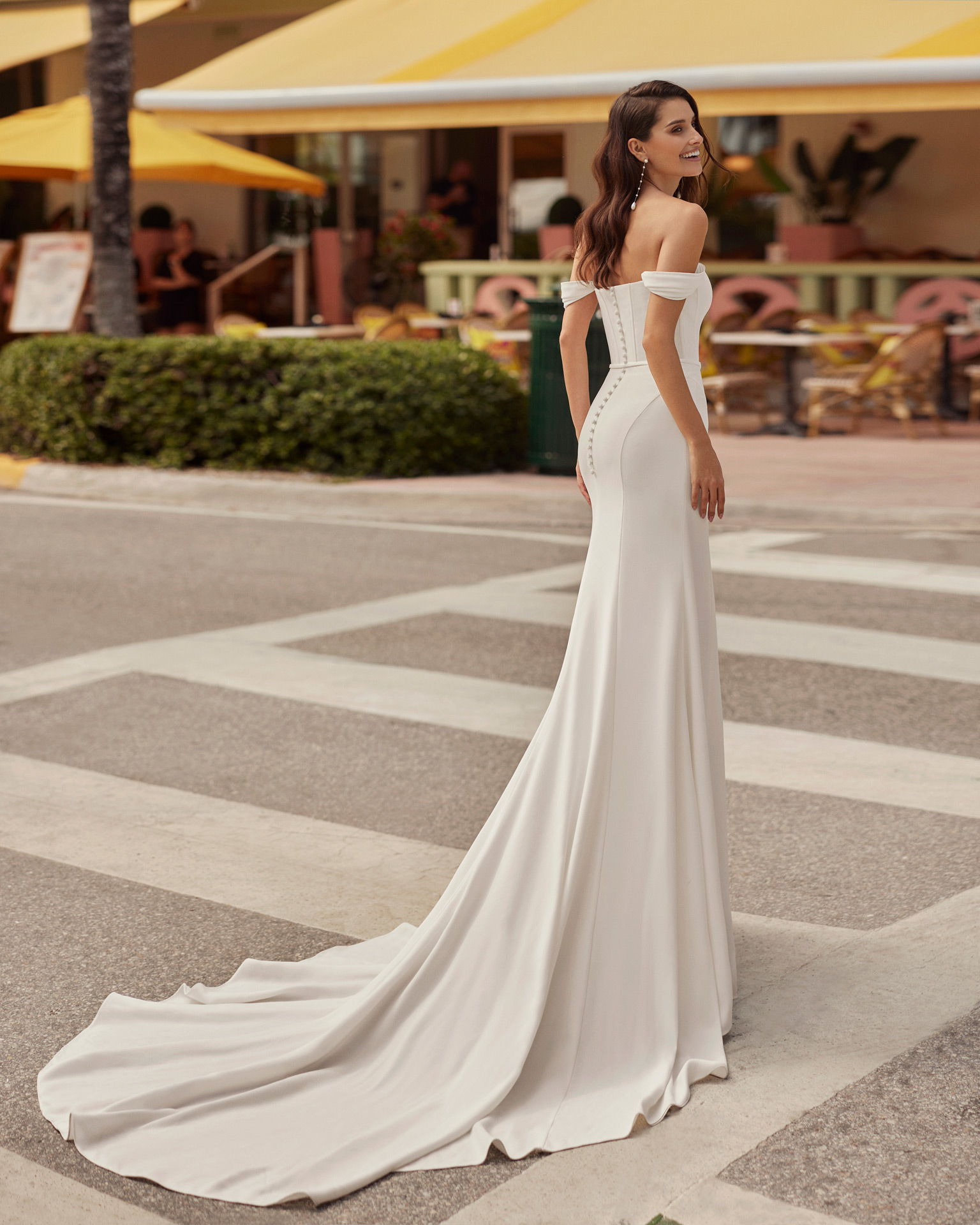 Elegant mermaid wedding dress, made in crepe. This on-trend Luna Novias design features a sweetheart neckline, buttoned back, detachable straps, and a crepe skirt with a front slit. LUNA_NOVIAS.