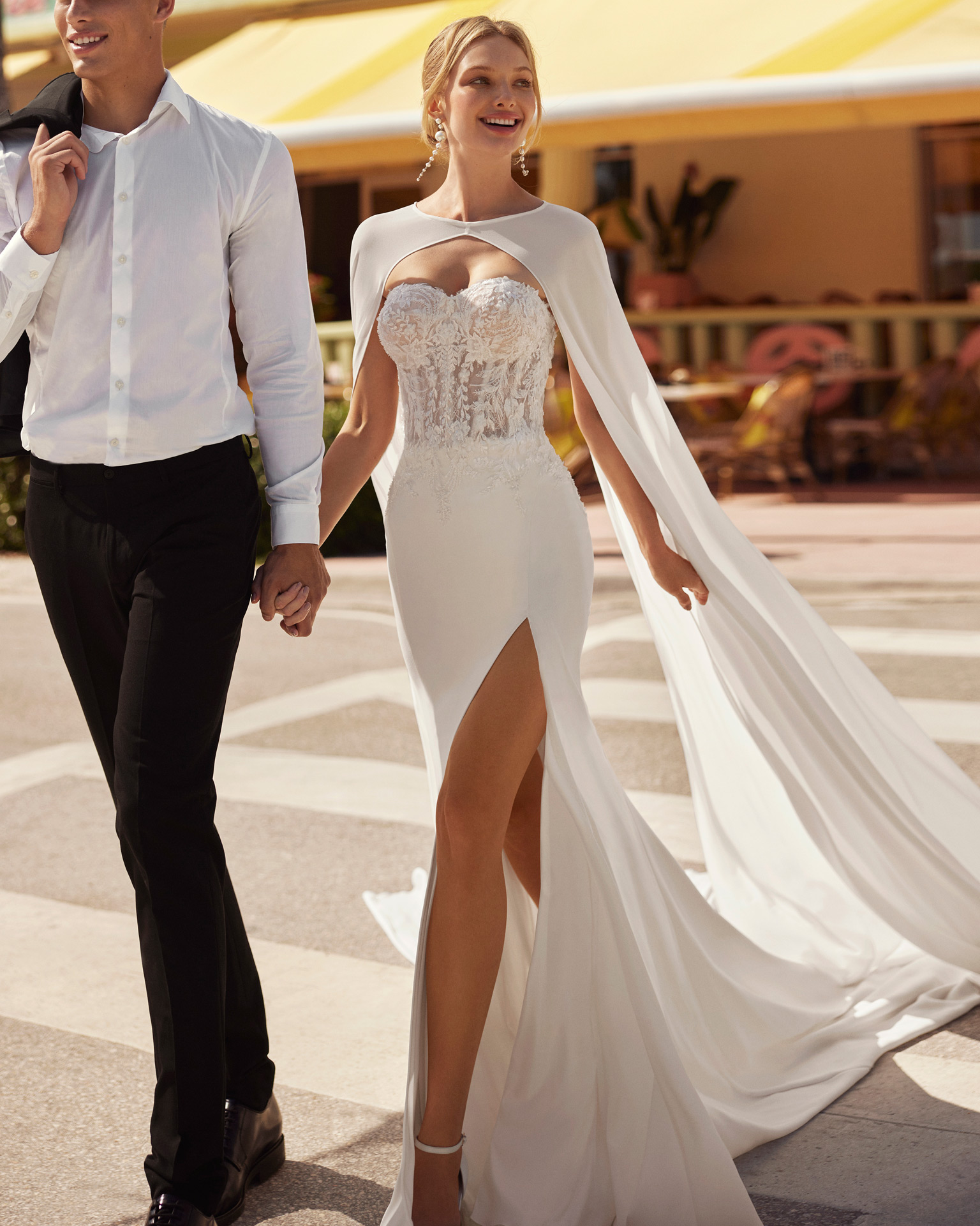 Simple mermaid-style wedding dress with beadwork and a crêpe skirt. With a sweetheart neckline, buttoned back and detachable sleeves. Skirt with front slit. No cape. Luna Novias wedding design. LUNA_NOVIAS.