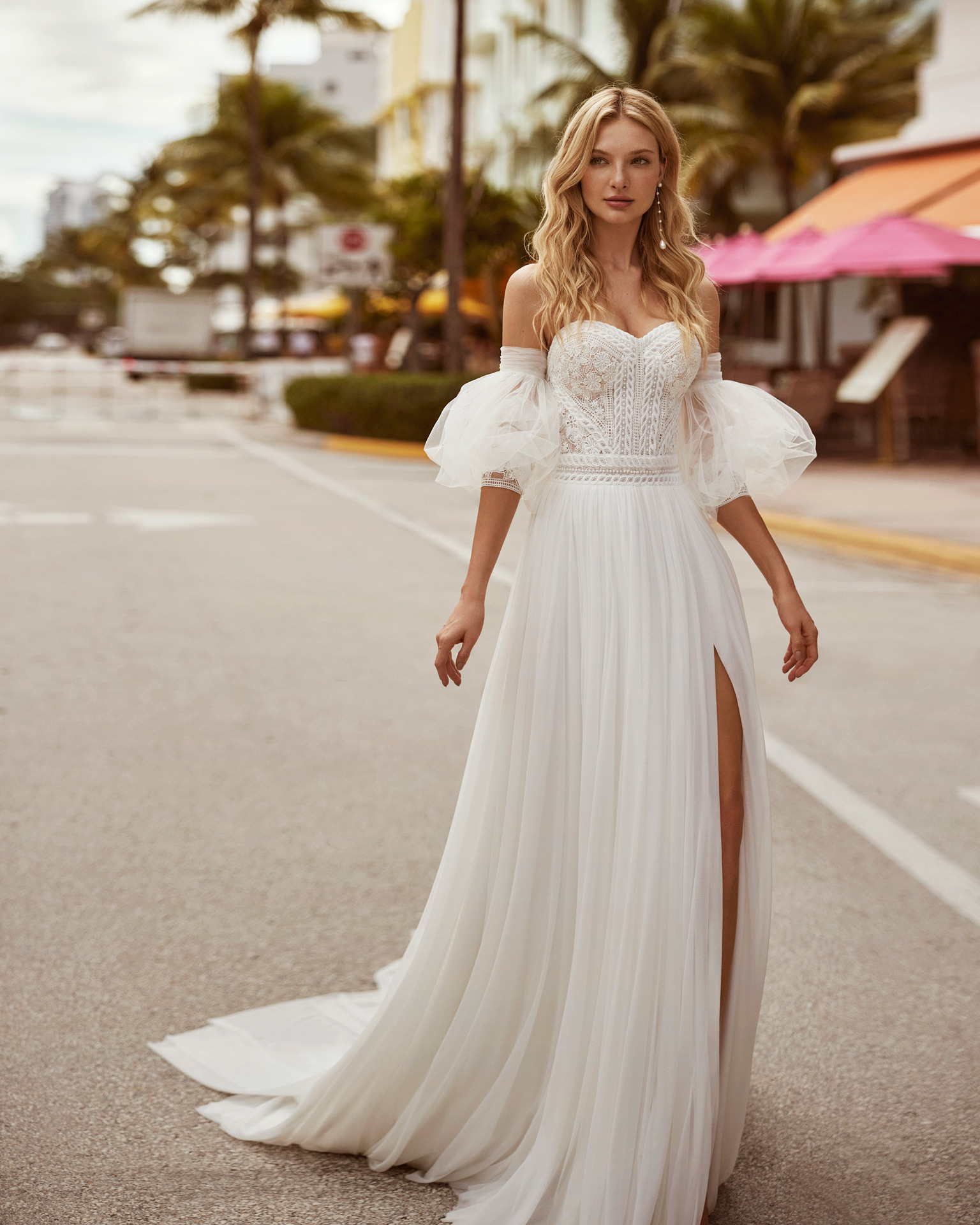 Princess-style A-line wedding dress, made in muslin combined with guipure lace. This delicate Luna Novias design features a sweetheart neckline, detachable sleeves and skirt with a front slit. LUNA_NOVIAS.