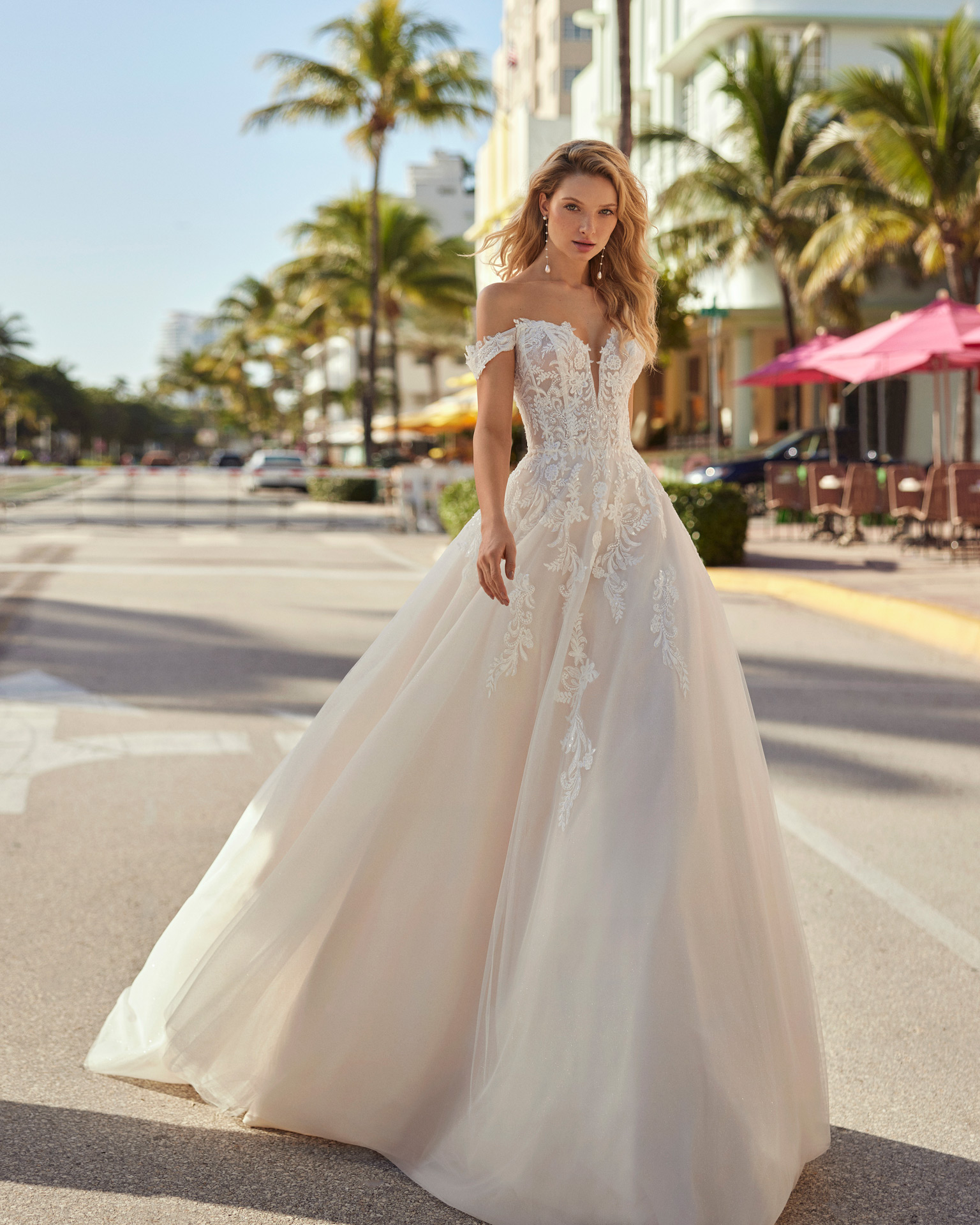Classic princess wedding dress, made in tulle. This delicate Luna Novias design features a V-neckline, open back, draped straps, and lace bodice with beadwork. LUNA_NOVIAS.