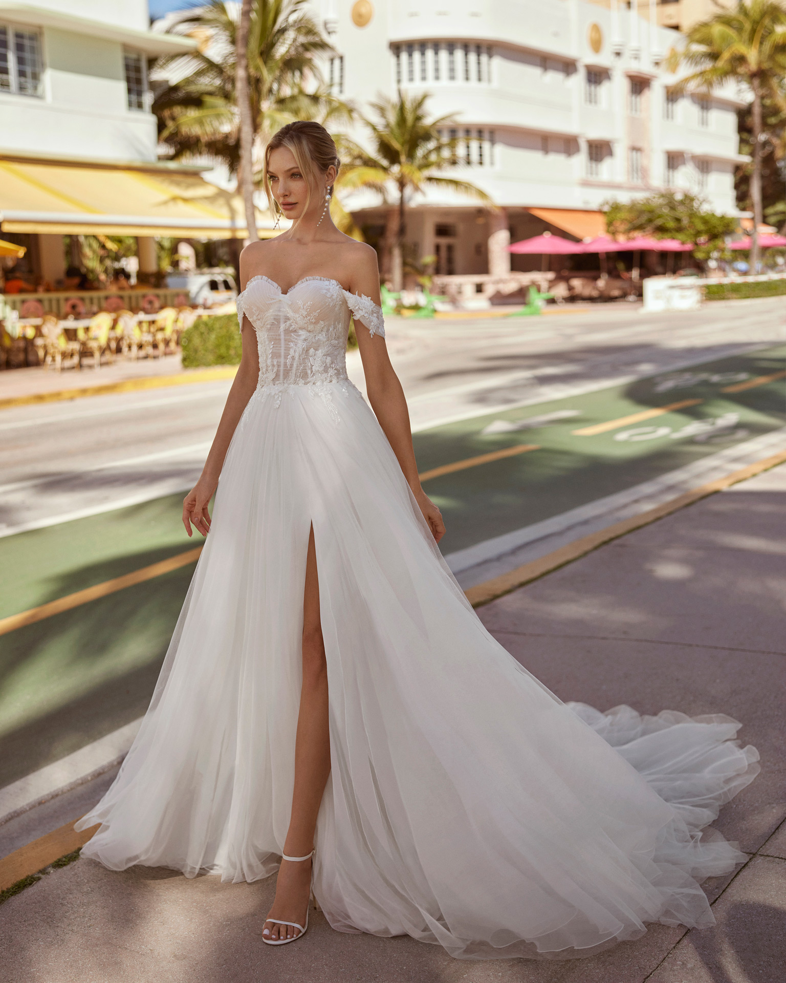 Romantic princess wedding dress. Crafted in tulle, it features a sweetheart neckline, buttoned back, detachable straps and skirt with a front slit. A delicate Luna Novias design. LUNA_NOVIAS.