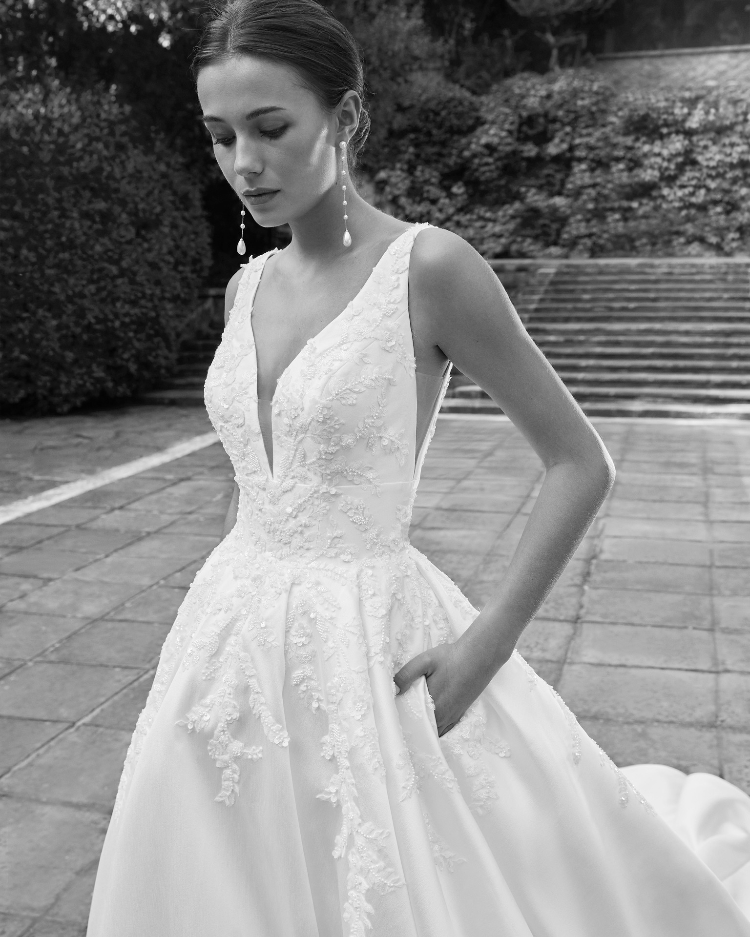 Elegant princess wedding dress, made in mikado embellished with lace and beadwork. This exclusive Luna Studio design features a V-neckline, V-back and skirt with pockets. LUNA_NOVIAS.
