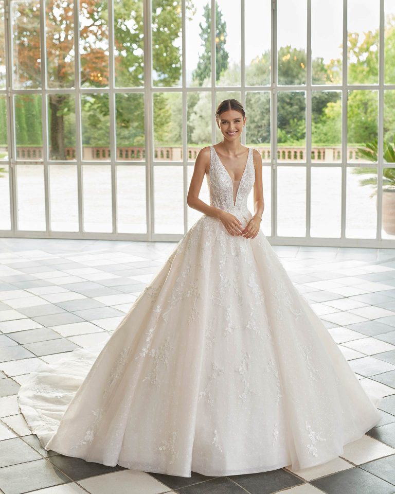 Princess-style wedding dress, with a full sheath-style skirt with pockets and beadwork mesh; with a deep-plunge neckline, a V-back and sides, and straps. Delicate Luna Studio design made of tulle and lace with beadwork. LUNA_NOVIAS.