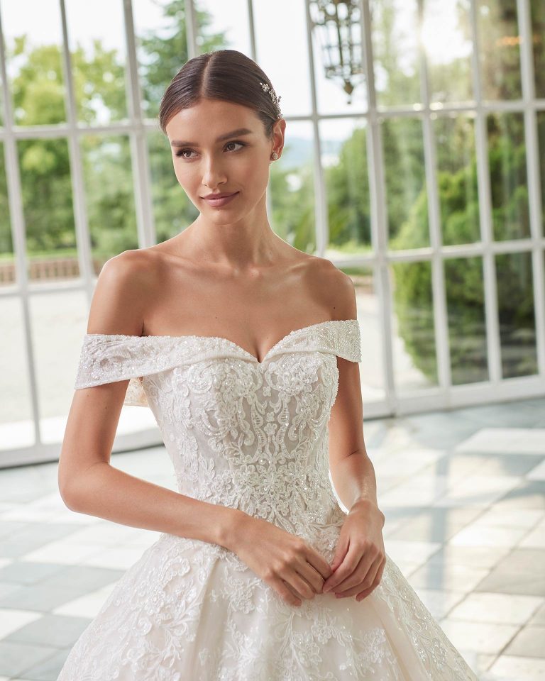 Princess-style wedding dress, with a full sheath-style skirt; with a sweetheart neckline, wrap sleeves, and a corset back. Delicate Luna Studio look made of tulle finished with beadwork lace. LUNA_NOVIAS.