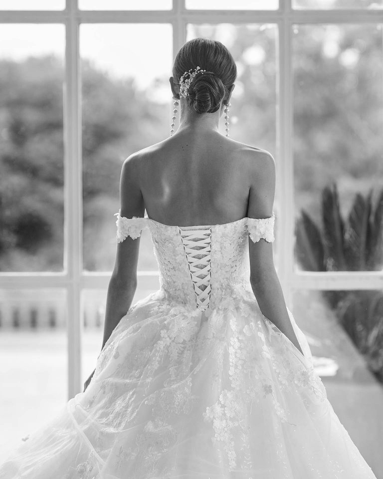 Princess-style wedding dress, with an appliqué and beadwork embellished bodice; with a deep-plunge neckline, a corset back, and dropped sleeves. Delicate Luna Studio look made of tulle and beadwork lace. LUNA_NOVIAS.