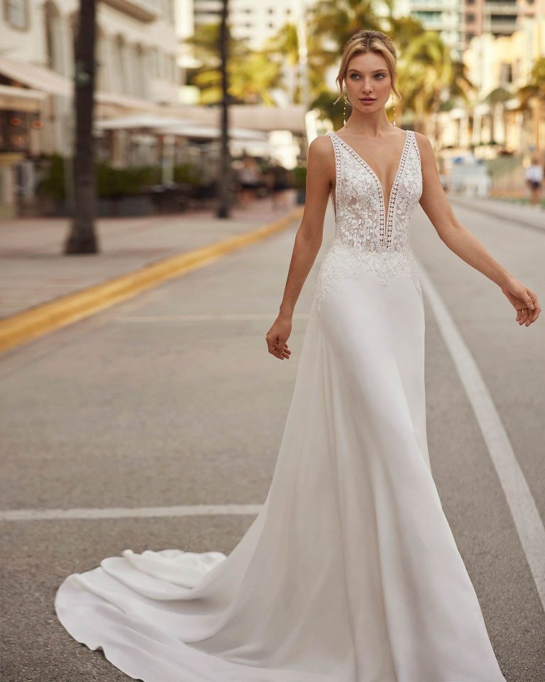 Simple A-line wedding dress, made in crepe. Grace comes guaranteed in this delicate Luna Novias design featuring a V-neckline, open back, straps, and lace bodice with beadwork. LUNA_NOVIAS.
